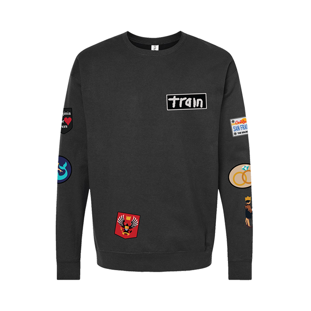 Black sweatshirt with various patches and a ’train’ logo on the chest.