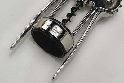 Stainless steel corkscrew with a black and silver circular base.